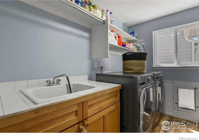 1169 Cooke Ct, Erie, CO 80516 - laundry room with cabinet space, washing machine and dryer, and wood finished floors