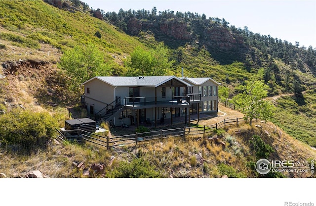 952 Steamboat Valley Rd, Lyons, CO 80540 - rear view of property with a fenced backyard, a deck, stucco siding, and a forest view