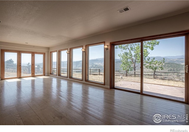 952 Steamboat Valley Rd, Lyons, CO 80540 - unfurnished room with a mountain view, wood finished floors, and a textured ceiling