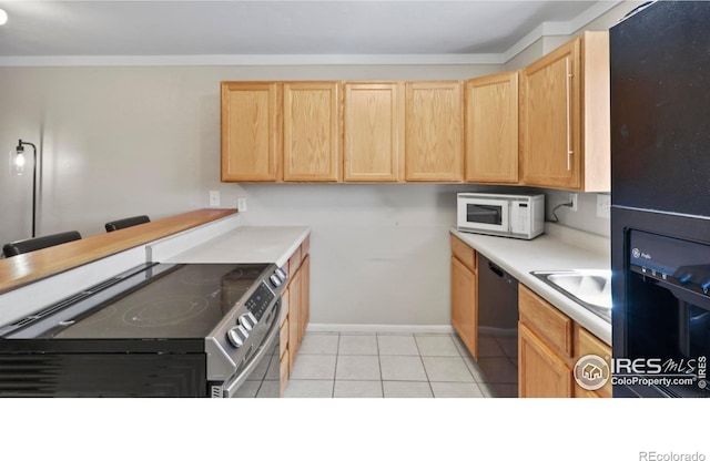 215 Chestnut St Unit A5, Windsor, CO 80550 - kitchen with black appliances, light brown cabinetry, light countertops, light tile patterned flooring, and ornamental molding