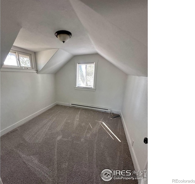 253 7th St, Frederick, CO 80530 - additional living space featuring plenty of natural light, lofted ceiling, a baseboard radiator, and carpet floors