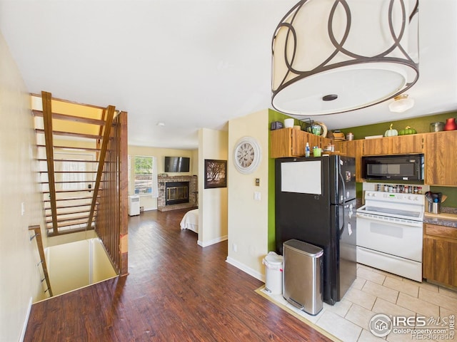 3200 Azalea Dr # 6, Fort Collins, CO 80526 - kitchen featuring black appliances, brown cabinetry, light wood-style floors, a brick fireplace, and open floor plan