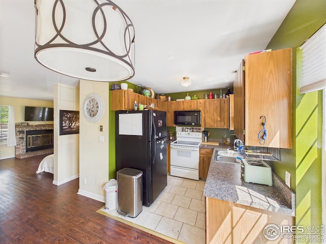 3200 Azalea Dr # 6, Fort Collins, CO 80526 - kitchen with black appliances, brown cabinets, light wood finished floors, and a fireplace