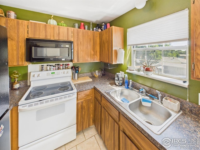 3200 Azalea Dr # 6, Fort Collins, CO 80526 - kitchen featuring white electric range oven, black microwave, light tile patterned floors, dark countertops, and freestanding refrigerator