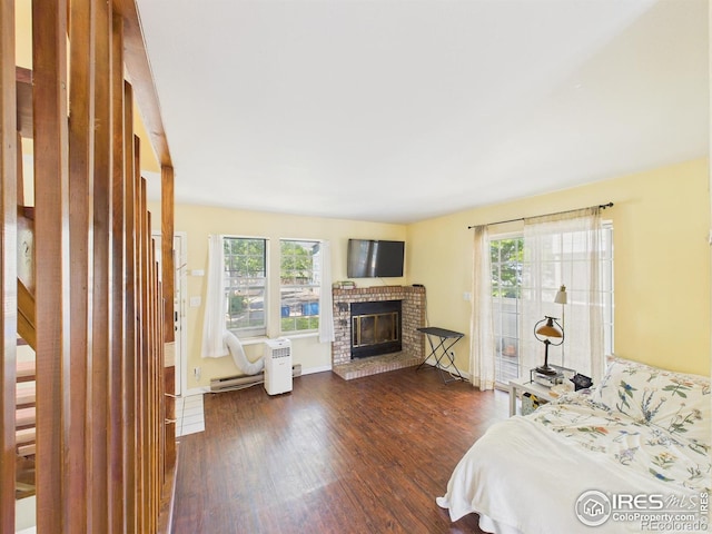 3200 Azalea Dr # 6, Fort Collins, CO 80526 - bedroom featuring dark wood-style floors, a brick fireplace, and a baseboard heating unit
