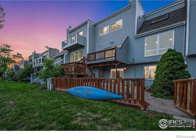 547 Spindrift Ct, Fort Collins, CO 80525 - back of house at dusk featuring a yard, stairs, and a balcony