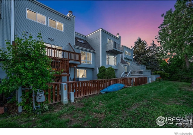 547 Spindrift Ct, Fort Collins, CO 80525 - back of house at dusk featuring a lawn