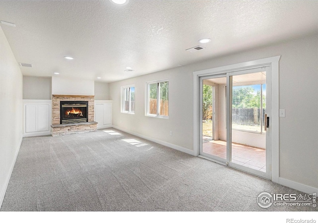 4386 Suncreek Dr, Loveland, CO 80538 - unfurnished living room featuring carpet floors, healthy amount of natural light, a textured ceiling, a fireplace, and recessed lighting