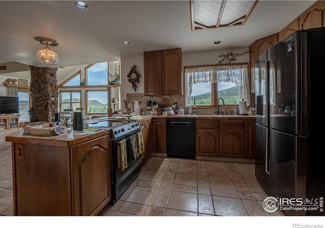 12711 Buckhorn Rd, Loveland, CO 80538 - kitchen with black appliances, a peninsula, decorative backsplash, brown cabinetry, and recessed lighting