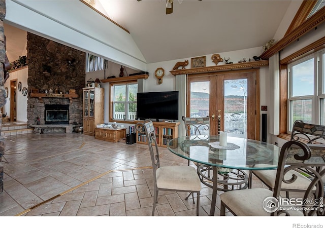 12711 Buckhorn Rd, Loveland, CO 80538 - dining space with french doors, a fireplace, ceiling fan, stone tile flooring, and high vaulted ceiling