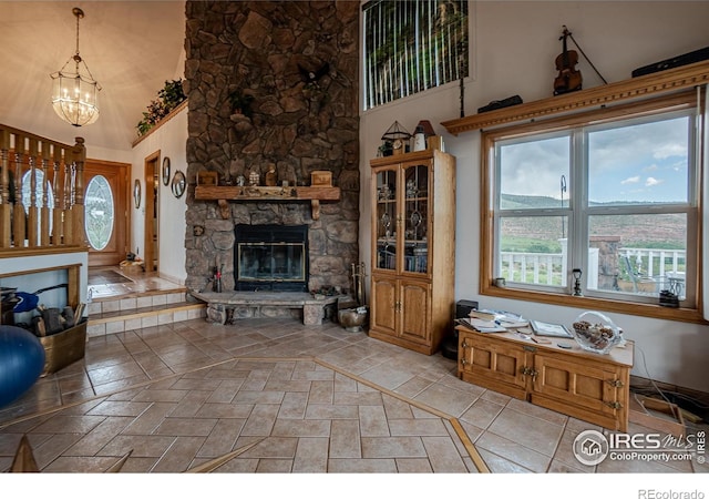 12711 Buckhorn Rd, Loveland, CO 80538 - living room featuring a fireplace, a towering ceiling, a chandelier, and plenty of natural light