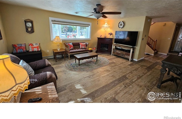 420 Applewood St, Brush, CO 80723 - living room with ceiling fan, wood finished floors, stairway, a textured ceiling, and a fireplace