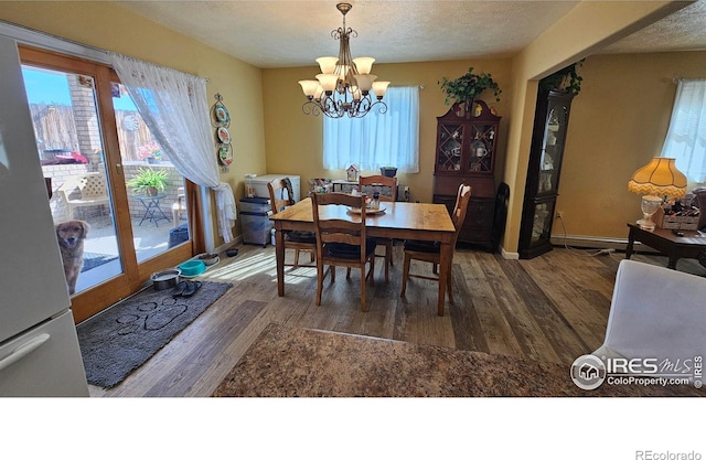 420 Applewood St, Brush, CO 80723 - dining space with a chandelier, wood finished floors, and a textured ceiling