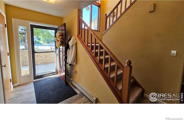420 Applewood St, Brush, CO 80723 - entrance foyer with a baseboard radiator, wood finished floors, and stairway