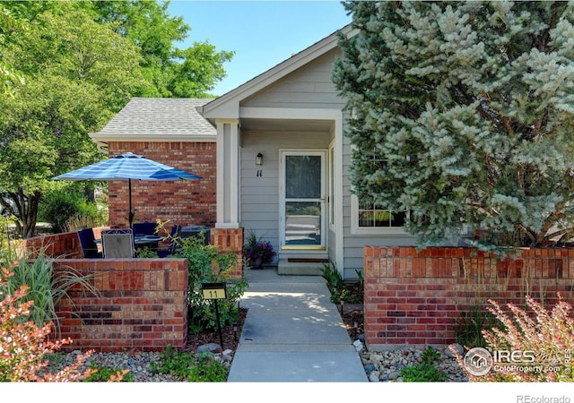 4500 Seneca St Unit 11, Fort Collins, CO 80526 - view of exterior entry featuring brick siding and a shingled roof