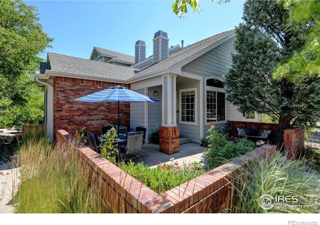 4500 Seneca St Unit 11, Fort Collins, CO 80526 - rear view of property with brick siding, a shingled roof, a patio, and a chimney