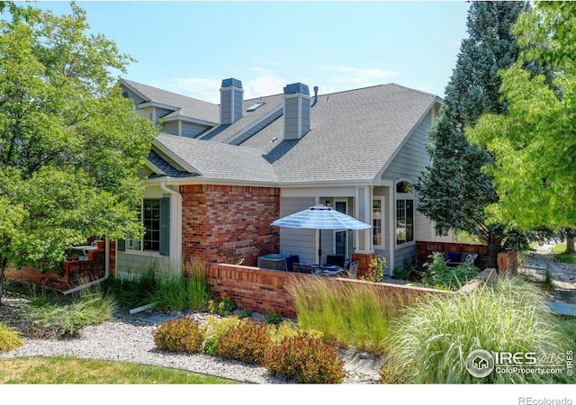 4500 Seneca St Unit 11, Fort Collins, CO 80526 - back of property with brick siding, a chimney, and roof with shingles