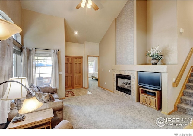 4500 Seneca St Unit 11, Fort Collins, CO 80526 - carpeted living room featuring high vaulted ceiling, a ceiling fan, a fireplace, and stairway
