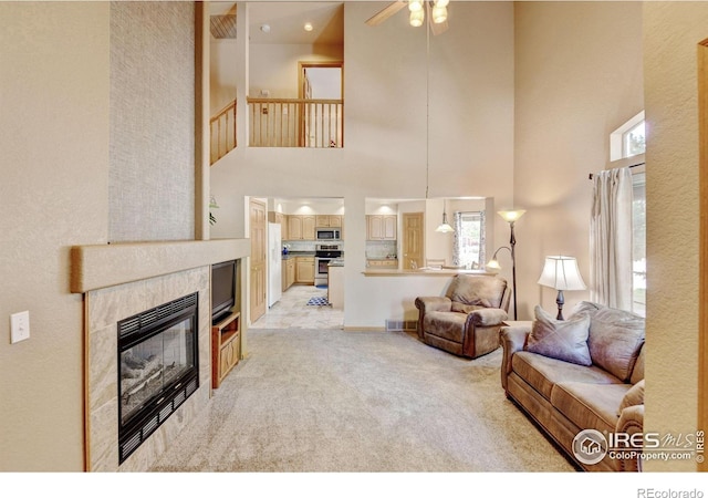 4500 Seneca St Unit 11, Fort Collins, CO 80526 - living area featuring a high ceiling, plenty of natural light, ceiling fan, light carpet, and a tile fireplace