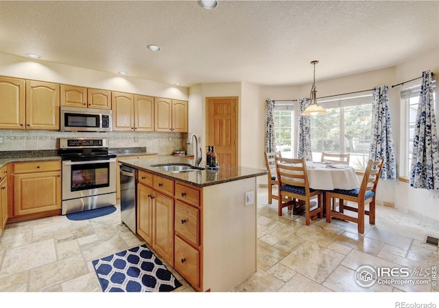 4500 Seneca St Unit 11, Fort Collins, CO 80526 - kitchen with appliances with stainless steel finishes, stone tile floors, dark stone counters, light brown cabinets, and a textured ceiling