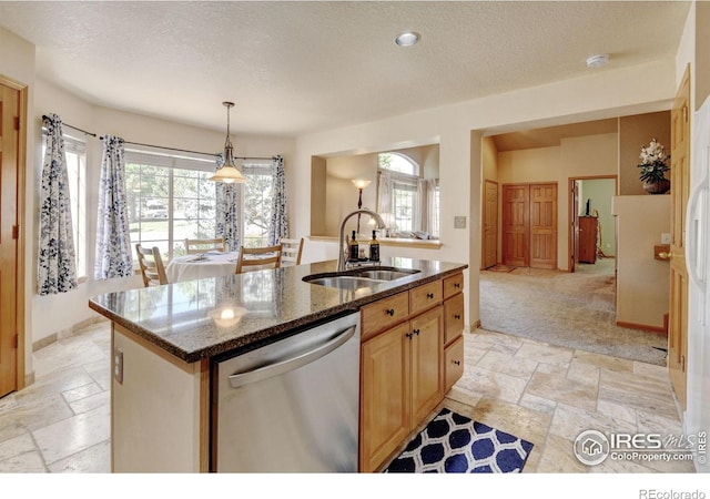 4500 Seneca St Unit 11, Fort Collins, CO 80526 - kitchen featuring stone tile flooring, stainless steel dishwasher, a textured ceiling, an island with sink, and dark stone counters