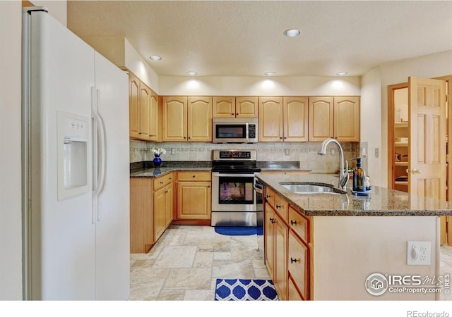 4500 Seneca St Unit 11, Fort Collins, CO 80526 - kitchen with appliances with stainless steel finishes, backsplash, dark stone countertops, an island with sink, and recessed lighting