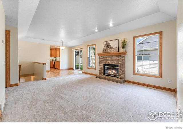 3822 W 11th St Unit 35, Greeley, CO 80634 - unfurnished living room featuring a tray ceiling, light carpet, and plenty of natural light