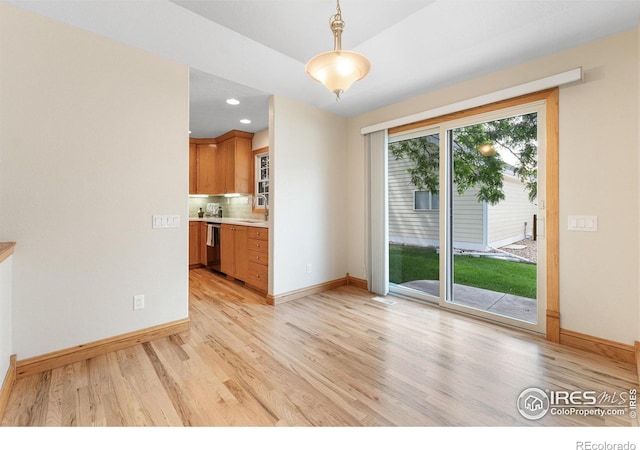 3822 W 11th St Unit 35, Greeley, CO 80634 - kitchen featuring light wood-style floors, tasteful backsplash, light countertops, pendant lighting, and recessed lighting