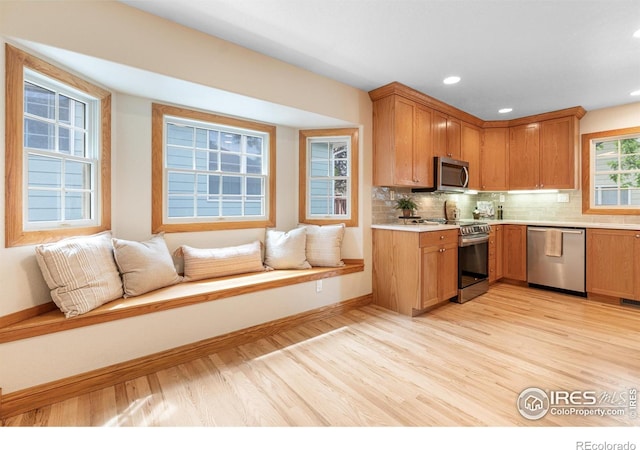 3822 W 11th St Unit 35, Greeley, CO 80634 - kitchen with light wood-style floors, light countertops, stainless steel appliances, open floor plan, and tasteful backsplash