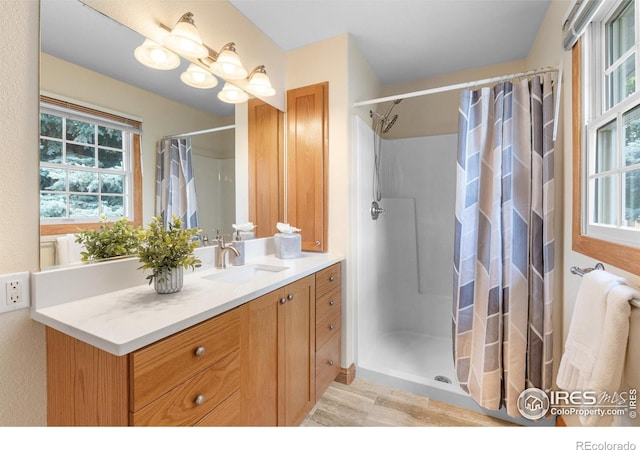 3822 W 11th St Unit 35, Greeley, CO 80634 - bathroom with vanity, a shower with curtain, and wood finished floors