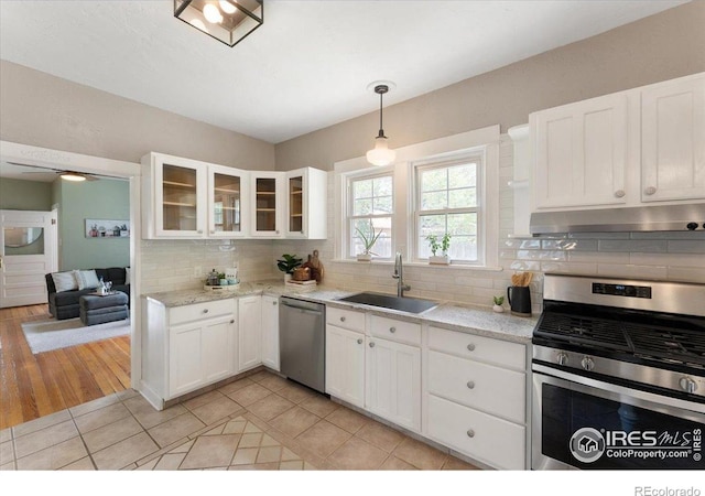 511 E Prospect Rd, Fort Collins, CO 80525 - kitchen with appliances with stainless steel finishes, white cabinets, tasteful backsplash, under cabinet range hood, and glass insert cabinets