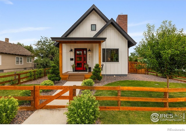 4306 Dixon St, Timnath, CO 80547 - modern farmhouse featuring board and batten siding, a fenced front yard, and a chimney