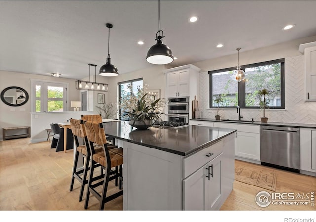 4306 Dixon St, Timnath, CO 80547 - kitchen with dark countertops, decorative backsplash, appliances with stainless steel finishes, recessed lighting, and white cabinets