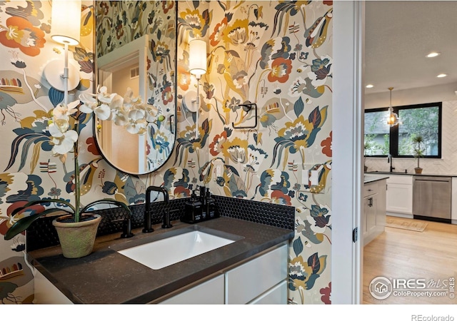 4306 Dixon St, Timnath, CO 80547 - bathroom with vanity, recessed lighting, tasteful backsplash, and wood finished floors