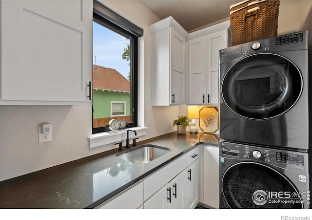 4306 Dixon St, Timnath, CO 80547 - washroom featuring stacked washing machine and dryer and cabinet space