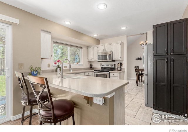 11417 King Way, Westminster, CO 80031 - kitchen featuring a peninsula, light countertops, a kitchen breakfast bar, stainless steel appliances, and recessed lighting