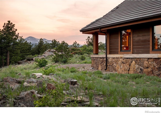 property exterior at dusk featuring a mountain view