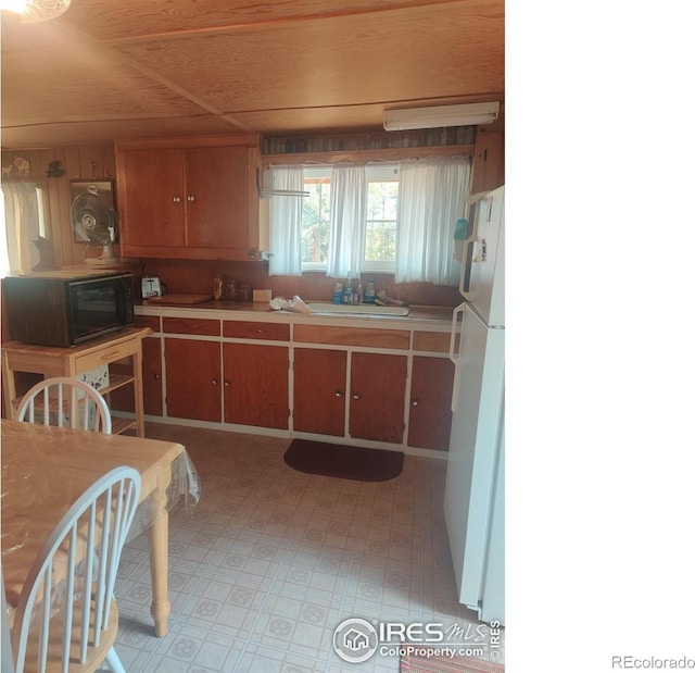 kitchen with white fridge, wooden ceiling, and sink