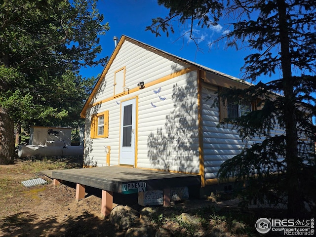 back of property with a shed and a deck