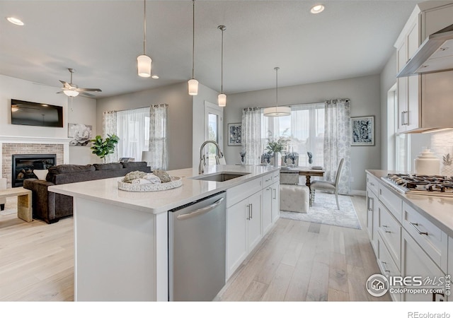 kitchen featuring white cabinetry, appliances with stainless steel finishes, sink, and a center island with sink