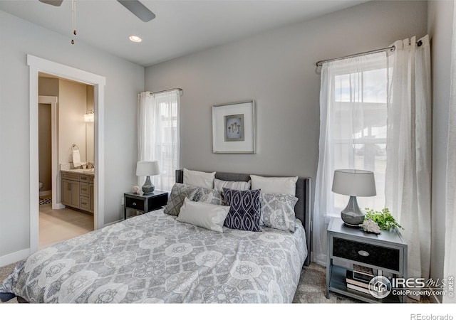 carpeted bedroom featuring ceiling fan and ensuite bath