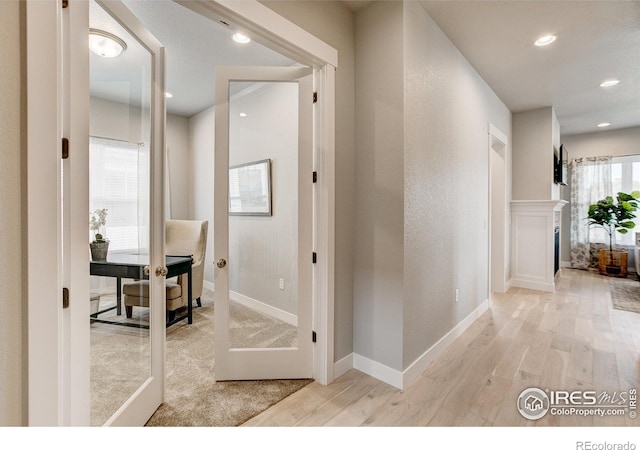 hallway featuring french doors and light hardwood / wood-style floors