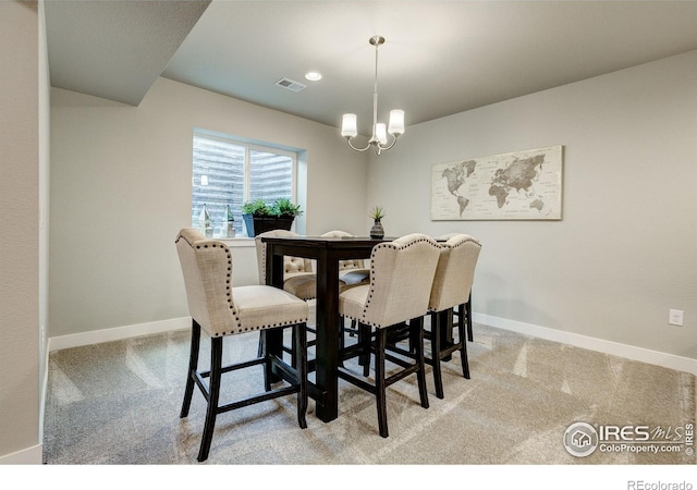 carpeted dining space with an inviting chandelier