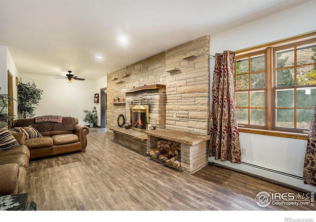 living room with ceiling fan, a fireplace, baseboard heating, and wood-type flooring