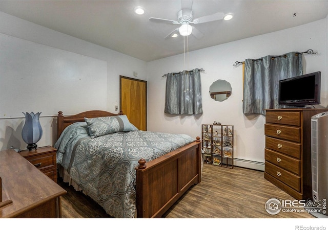 bedroom featuring ceiling fan, hardwood / wood-style flooring, and a baseboard radiator