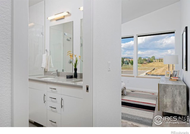 bathroom with lofted ceiling, walk in shower, and vanity