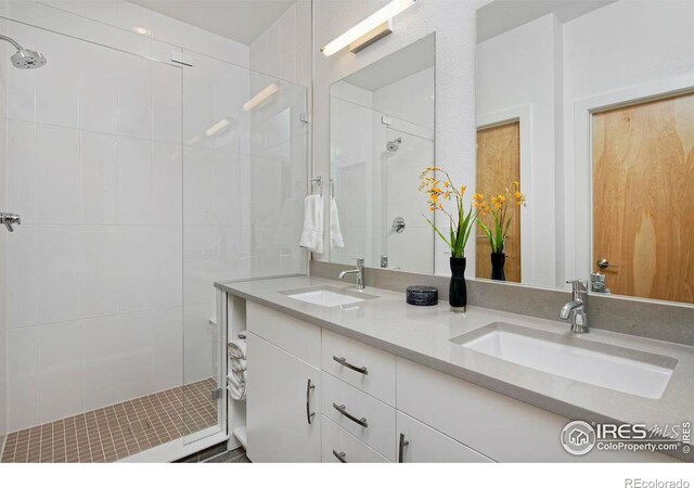 bathroom with a tile shower and vanity