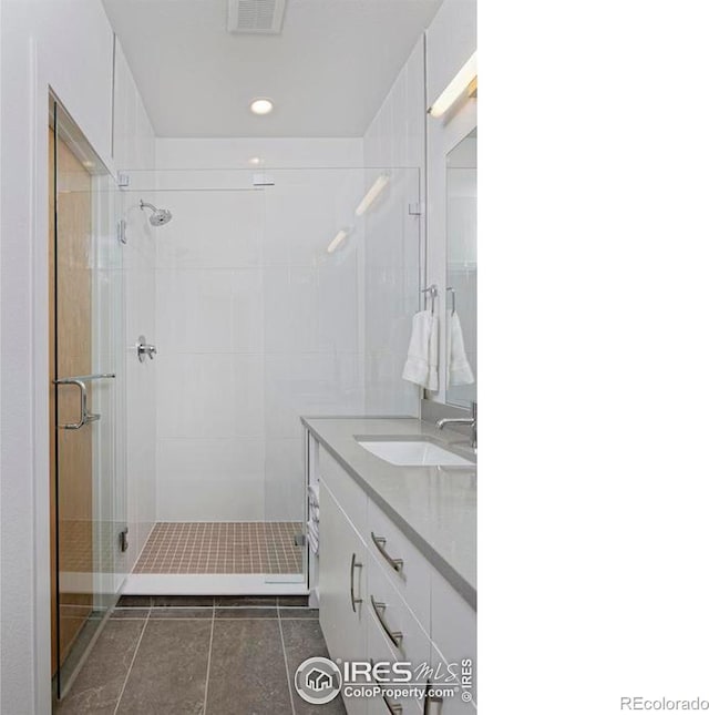 bathroom with tile patterned flooring, vanity, and an enclosed shower