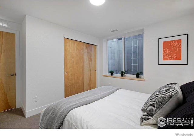 bedroom featuring a closet, visible vents, carpet flooring, and baseboards