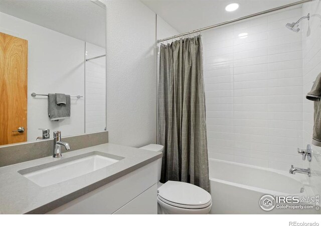 full bathroom with toilet, shower / tub combo with curtain, and vanity